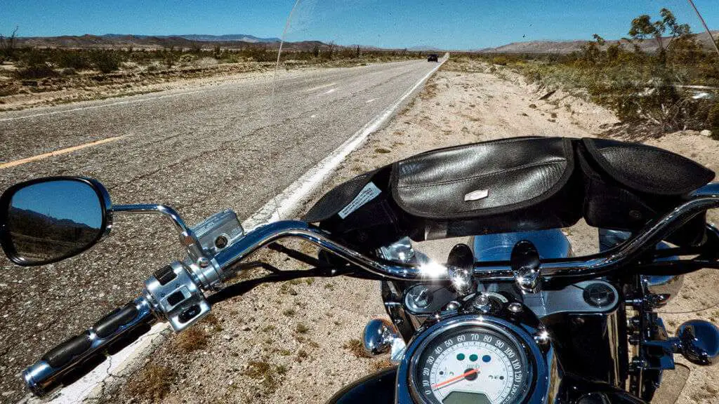 Motorcycle with windshield parked on the side of the road