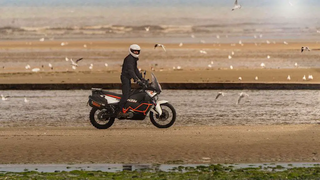 Man riding a KTM on a beach