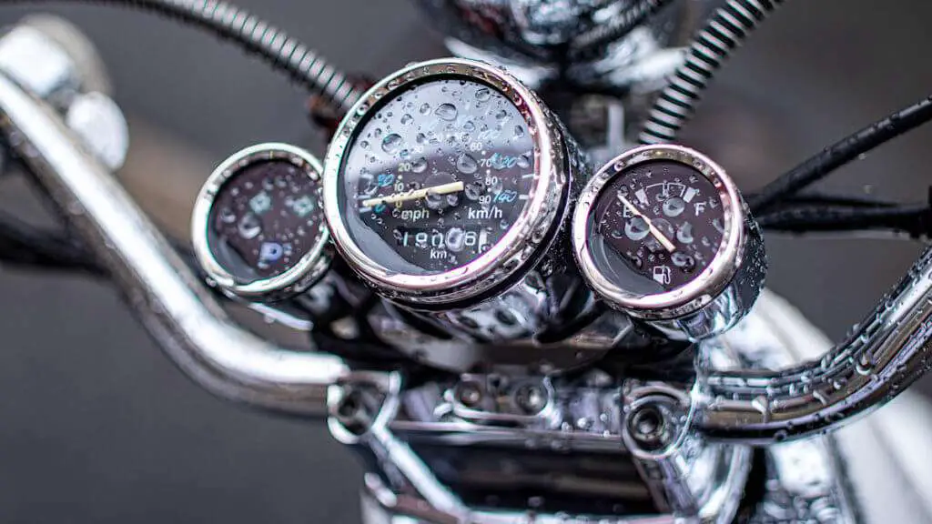 Close-up of a wet motorcycle dashboard