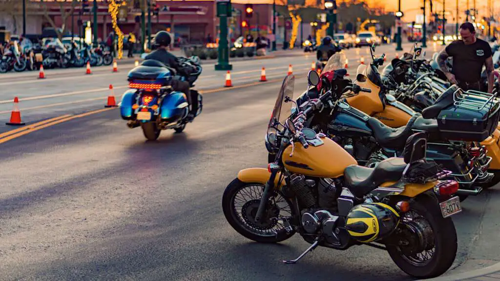 Multiple motorcycles parked on the side of the road