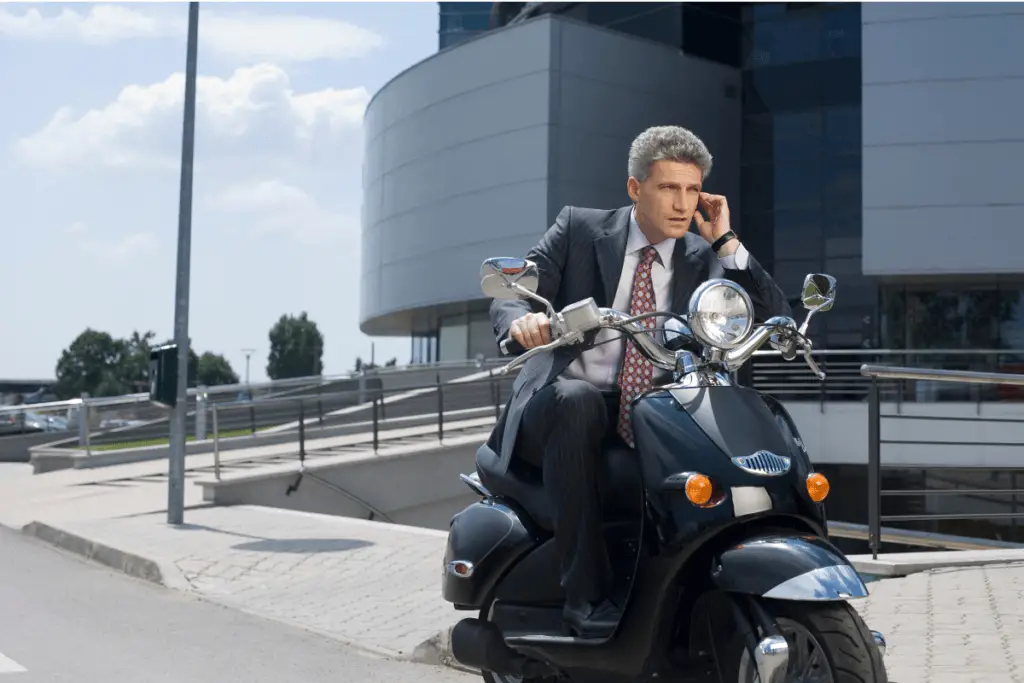 Man talking on the phone on a scooter