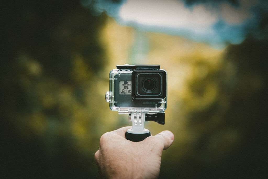 Hand holding a GoPro in focus