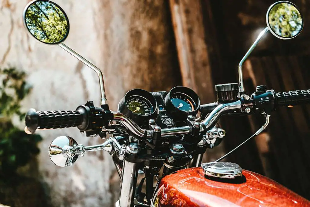 Red motorcycle with round mirrors close-up