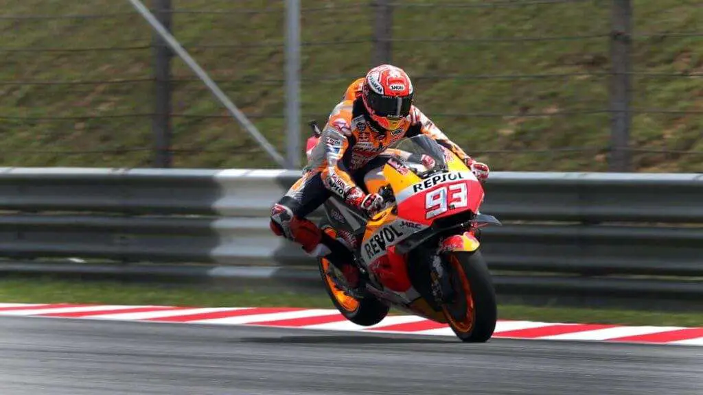 man in orange helmet riding orange and white sports bike