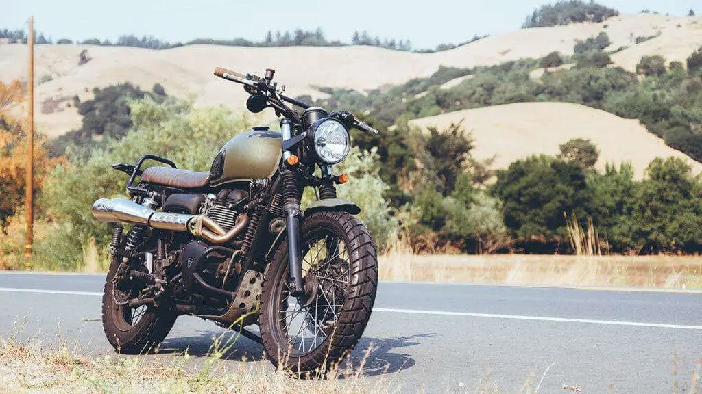 Dark green motorcycle on the side of the road