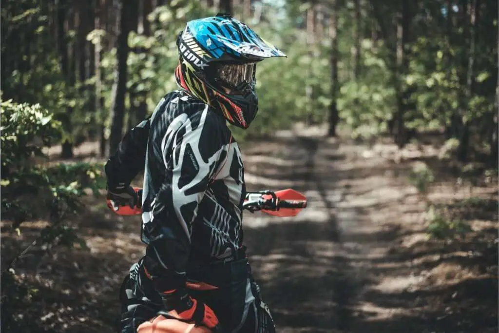 person wearing a motocross helmet and suit looking back