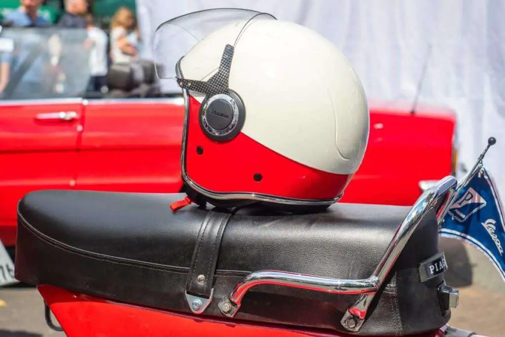 white and red helmet on top of a motorcycle seat