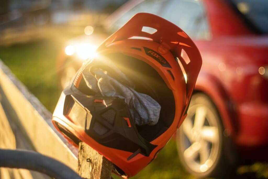 Dirtbike helmet hanging in the sun on a fence