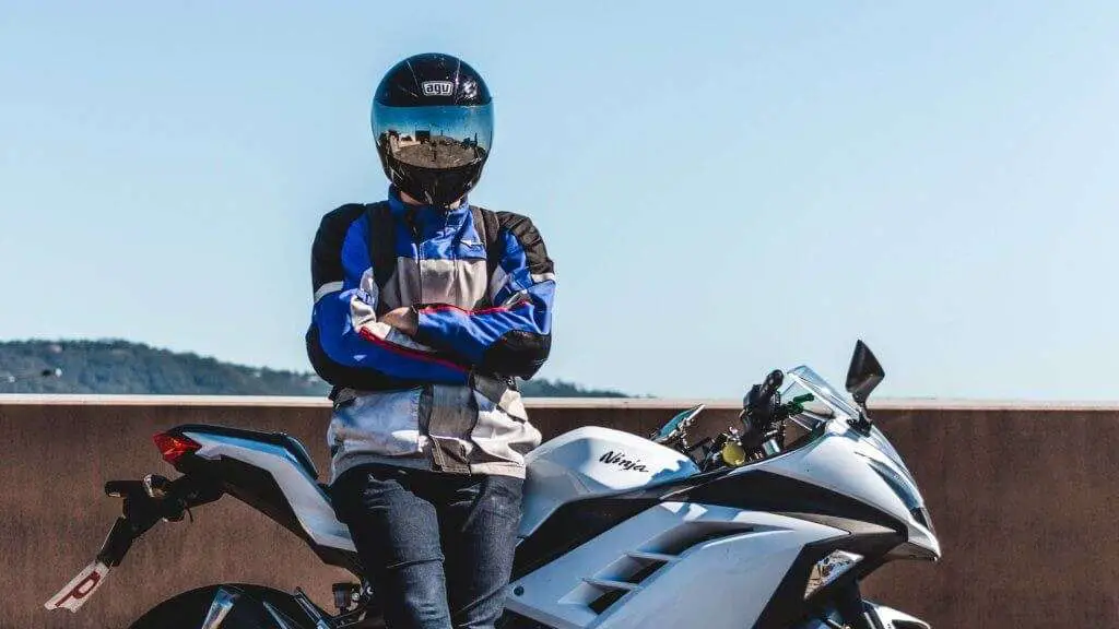 Person wearing a blue and gray mesh jacket and a black helmet