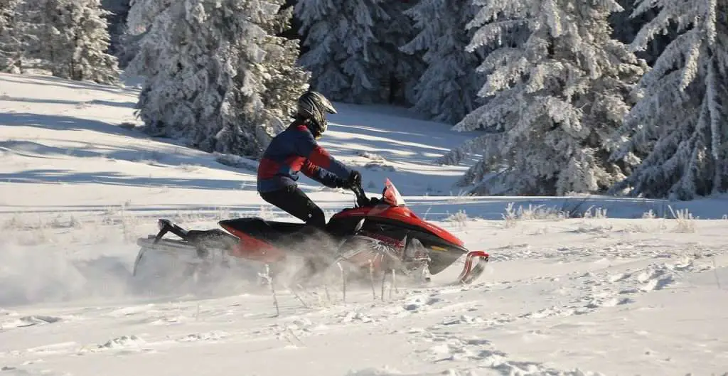 Person riding a red snowmobile