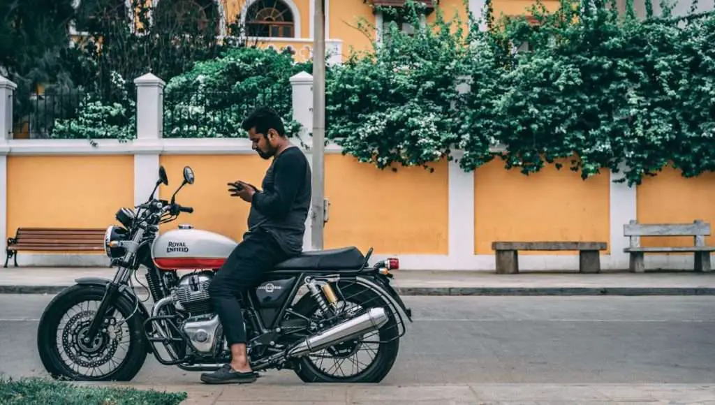 Man stopped on motorcycle checking phone