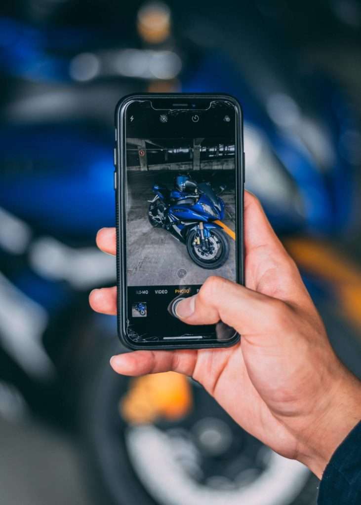 Person taking a photo of a motorcycle