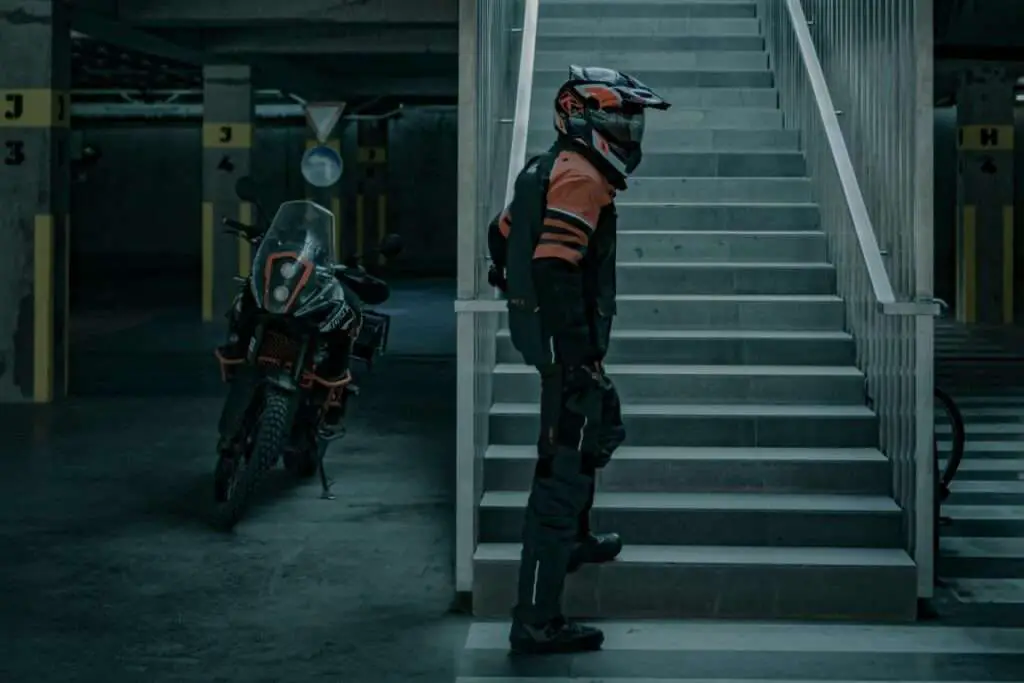 Man wearing full body motorcycle gear walking up stairs 