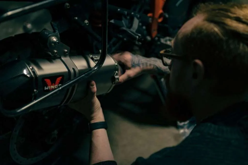 Mechanic working on a motorcycle exhaust