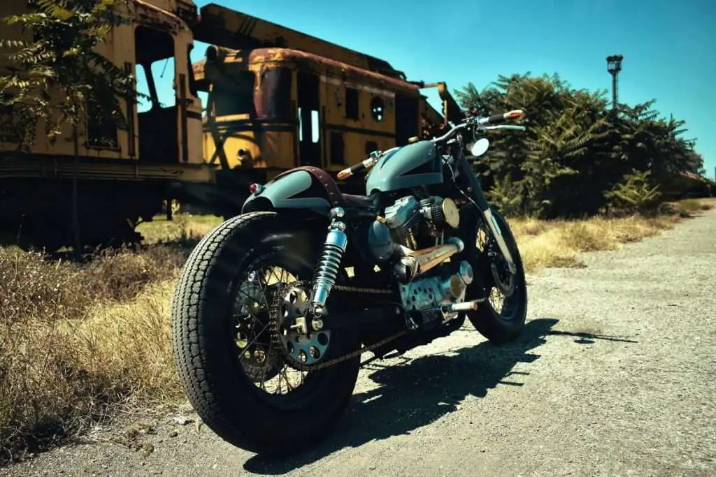 Custom motorcycle next to an abandoned train.