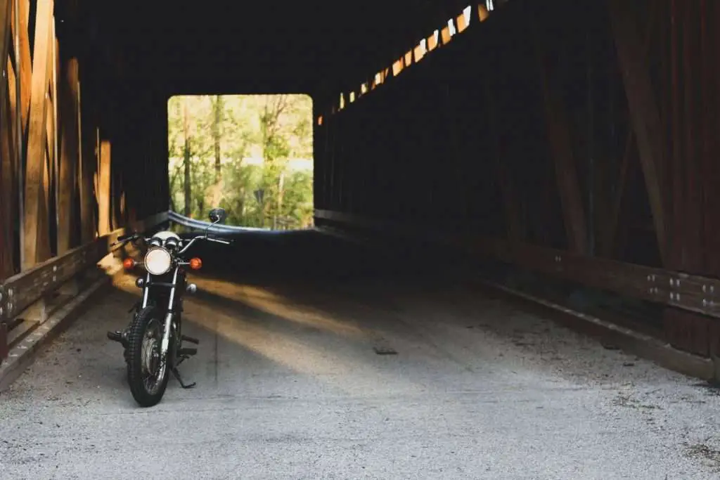 Motorcycle with headlight on parked in a tunnel bridge
