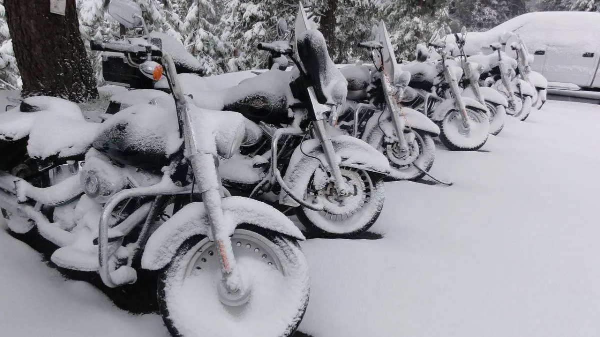 parked motorcycles covered in snow