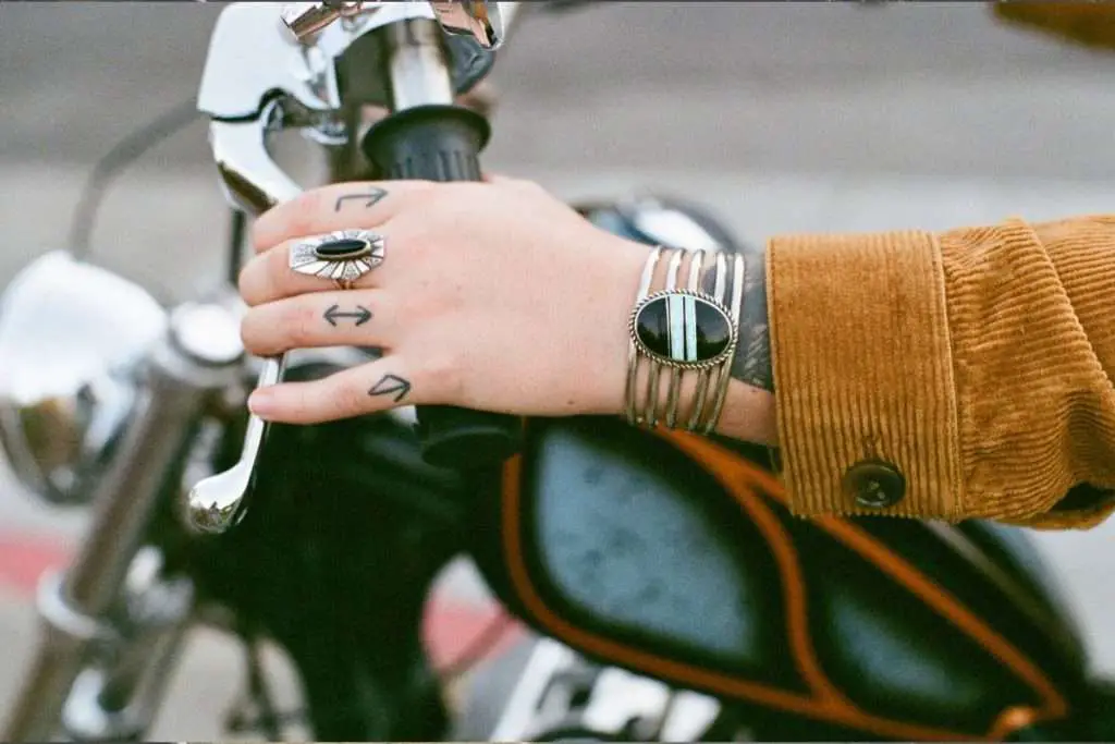 Hand with tattoo on motorcycle handlebar