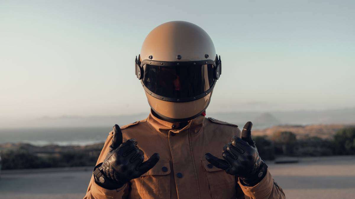 Man with motorcycle helmet holding hands in front