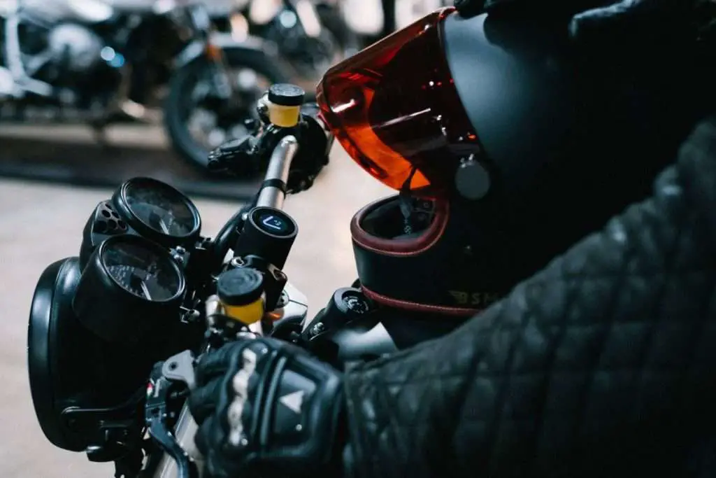 Motorcycle rider hand on handlebar wearing gloves