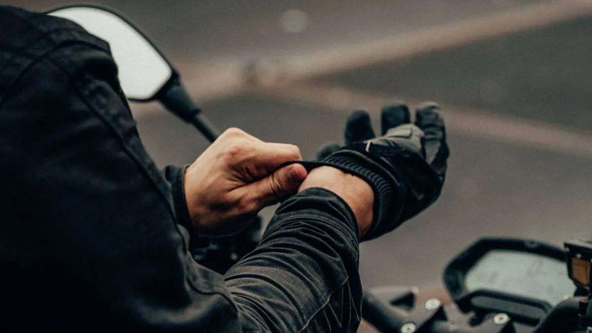 Person putting black motorcycle gloves on